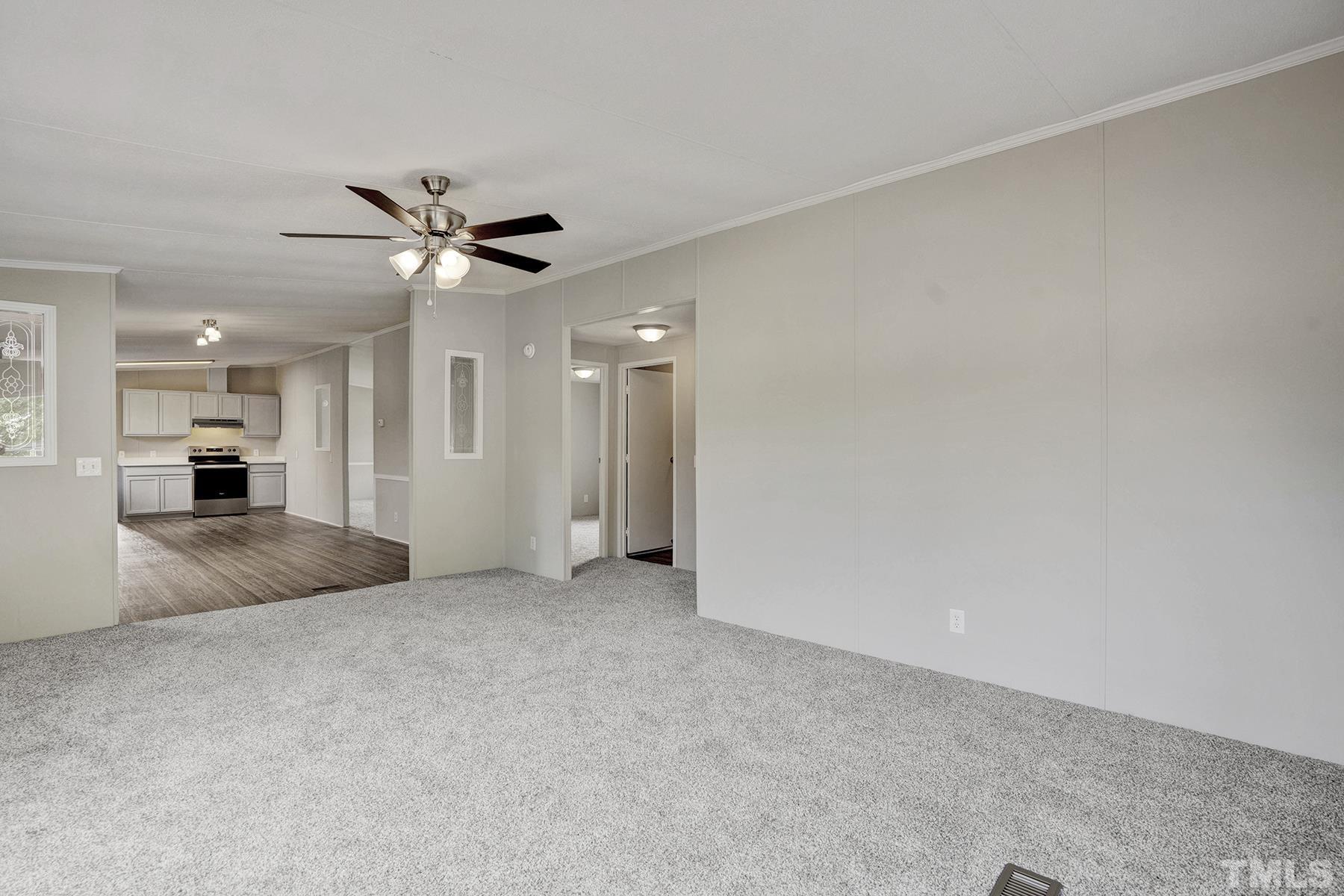 105 Rains Crossroads Road Selma, NC 27576 - Photo 11 of 30 an empty room with a kitchen and a ceiling fan