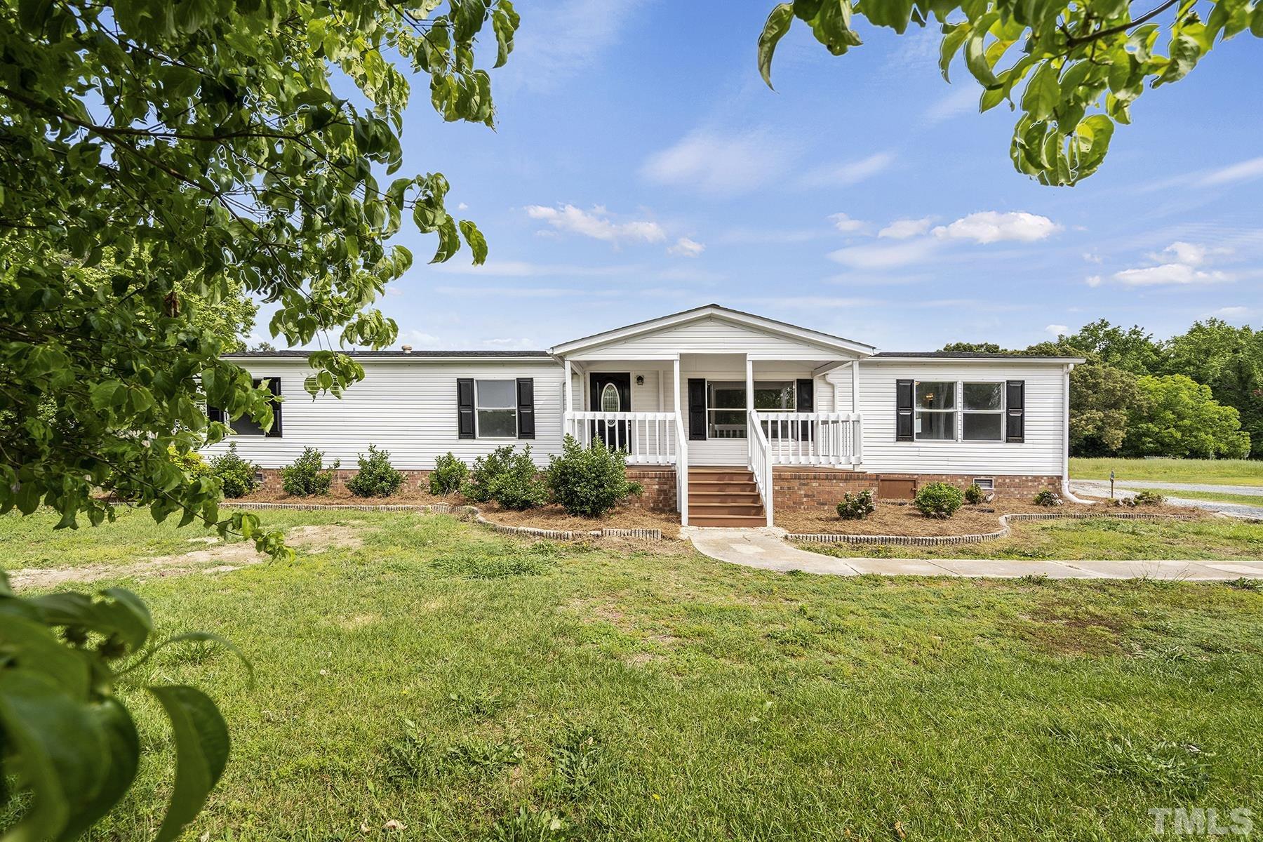 105 Rains Crossroads Road Selma, NC 27576 - Photo 2 of 30 a front view of a house with a yard table and chairs
