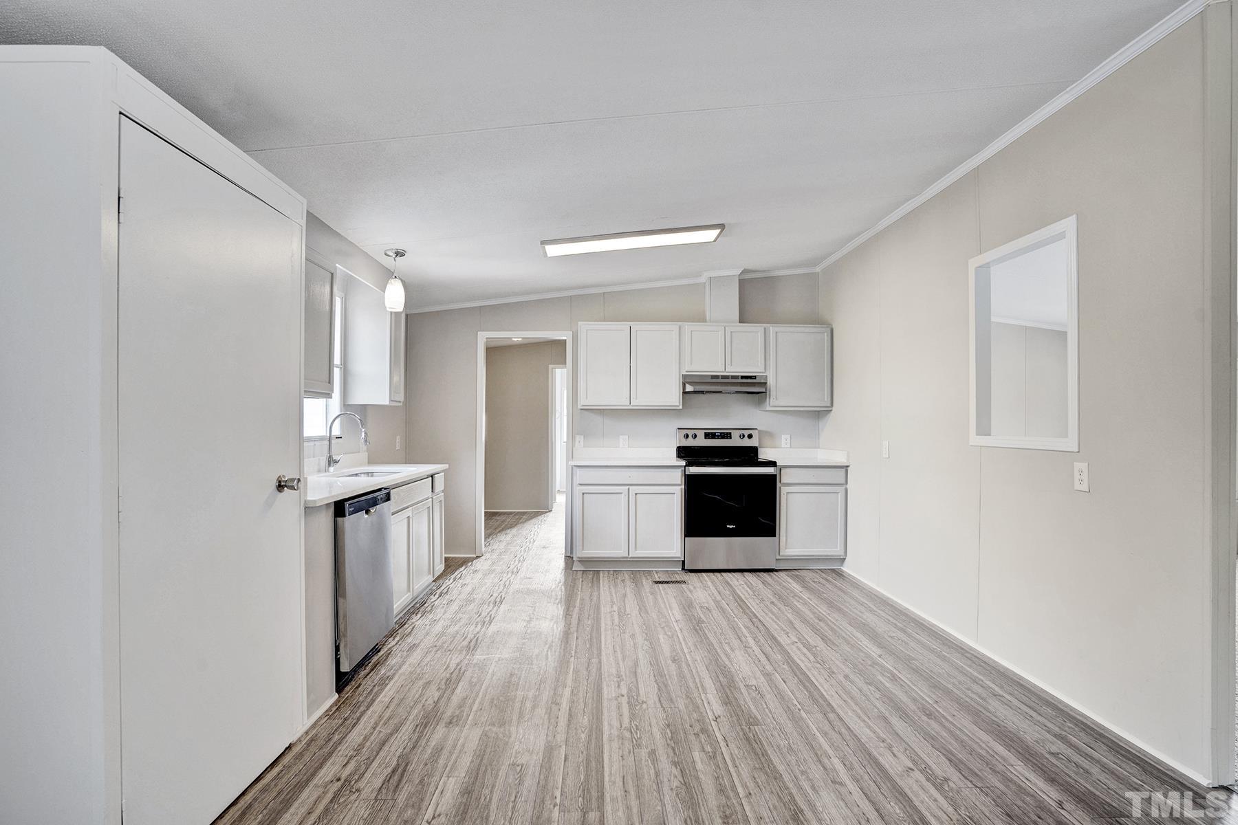 105 Rains Crossroads Road Selma, NC 27576 - Photo 8 of 30 a large kitchen with a wooden floor and stainless steel appliances