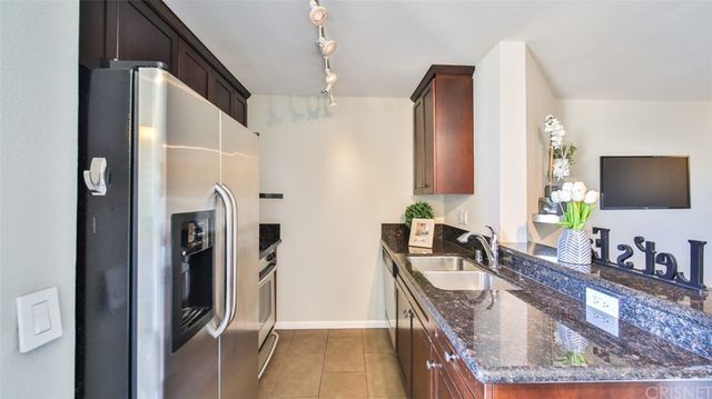 a bathroom with a granite countertop double vanity sink and mirror
