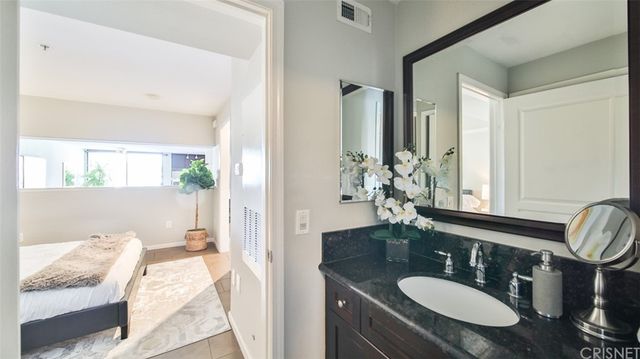 a bathroom with a granite countertop sink and a mirror