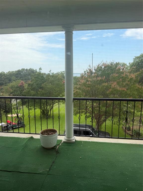 83 Bass Road Pottsboro, TX 75076 - Photo 19 of 31 Screened outdoor balcony featuring a white support column, black ornate railing, and green artificial turf flooring