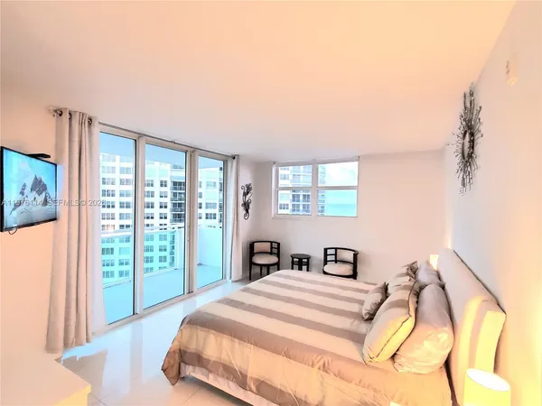 a bedroom with a bed and a large window