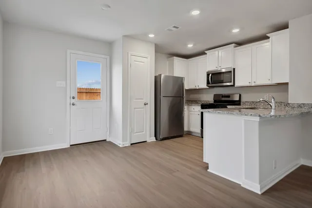 a kitchen with stainless steel appliances a refrigerator sink and microwave