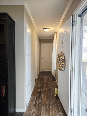 a view of a hallway with wooden floor and closet