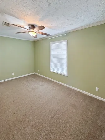 an empty room with a ceiling fan and window