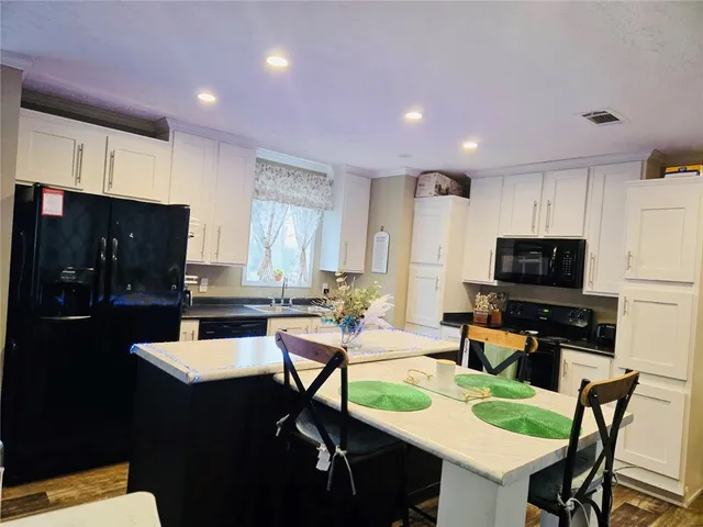 a kitchen with a table chairs refrigerator and microwave
