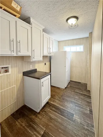 a kitchen with granite countertop white cabinets and white appliances