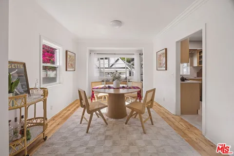a view of a dining room with furniture a rug and wooden floor