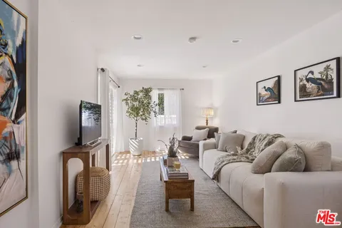 a living room with furniture a flat screen tv and a window