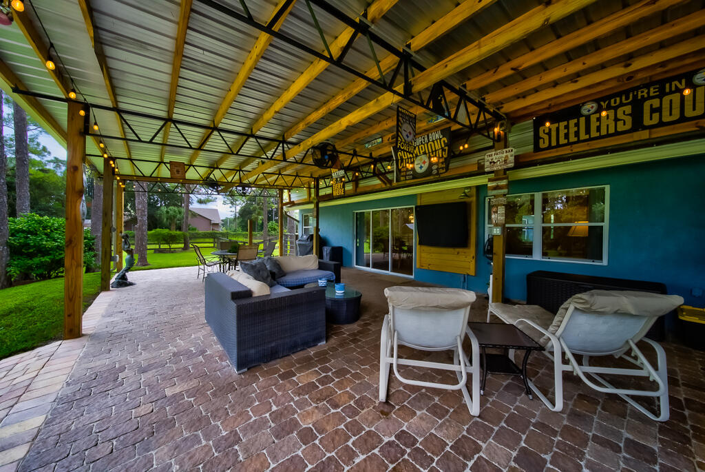 15733 Temple Boulevard Loxahatchee, FL 33470 - Photo 11 of 27 a view of a chairs and table in patio with a small yard