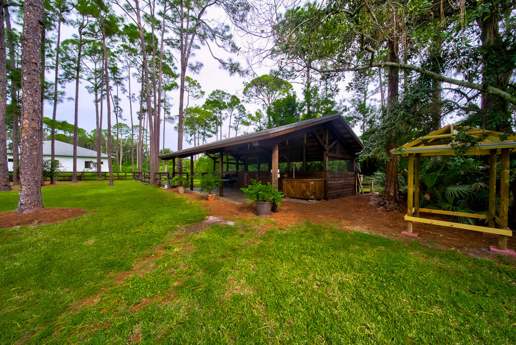 15733 Temple Boulevard Loxahatchee, FL 33470 - Photo 14 of 27 a view of a chair and table in backyard of the house