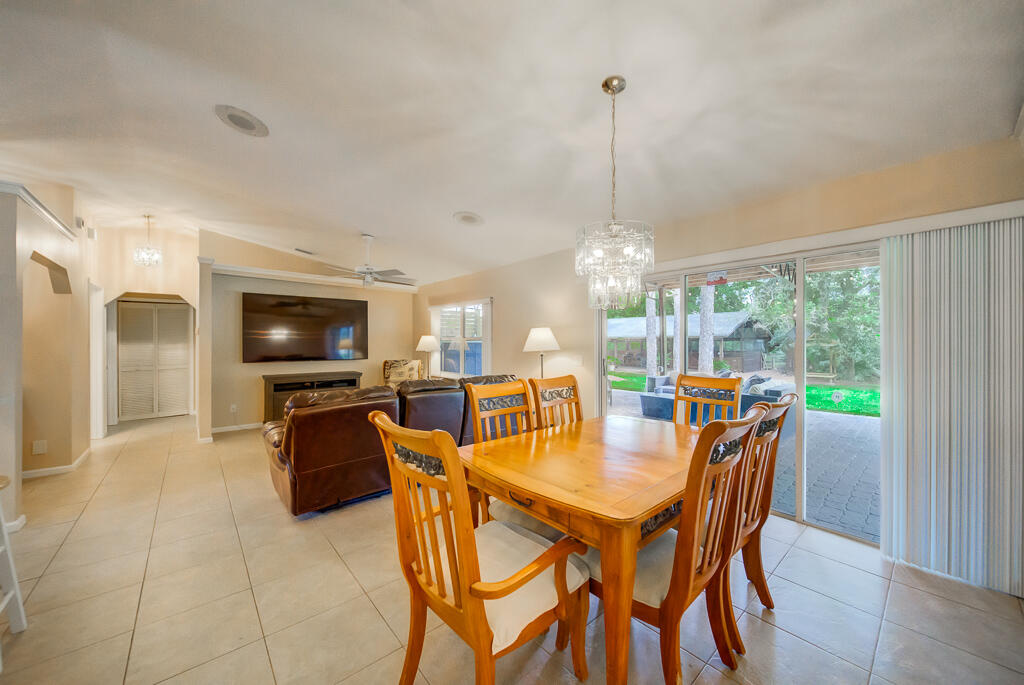 15733 Temple Boulevard Loxahatchee, FL 33470 - Photo 2 of 27 a dining room with furniture a chandelier and wooden floor