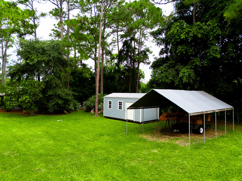 15733 Temple Boulevard Loxahatchee, FL 33470 - Photo 21 of 27 a front view of a house with garden