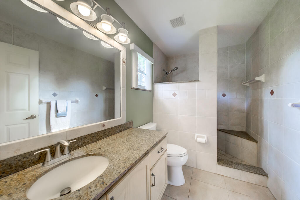 15733 Temple Boulevard Loxahatchee, FL 33470 - Photo 5 of 27 a bathroom with a granite countertop sink toilet and shower