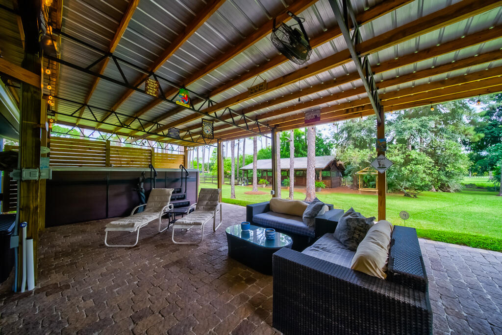 15733 Temple Boulevard Loxahatchee, FL 33470 - Photo 9 of 27 a outdoor space with patio couch and a garden