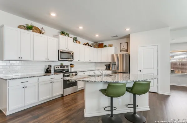 a kitchen with stainless steel appliances kitchen island granite countertop a stove a sink and a cabinets