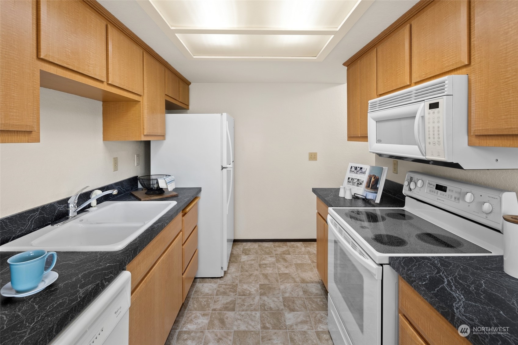 4100 Lake Washington Boulevard North, Unit A202 Renton, WA 98056 - Photo 11 of 25 a kitchen with granite countertop a sink stove and refrigerator