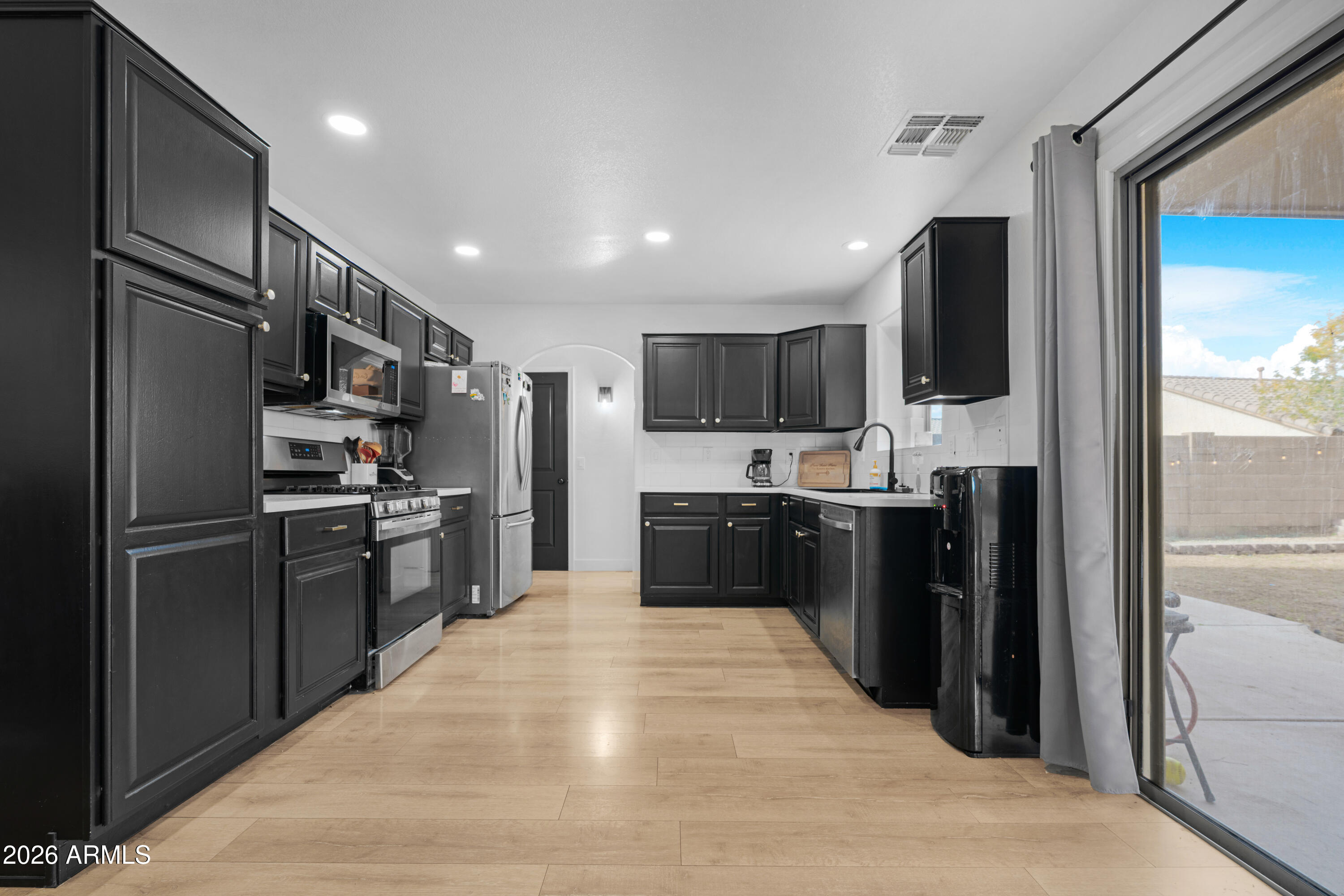 1810 East Milky Way Gilbert, AZ 85295 - Photo 10 of 46 a kitchen with kitchen island stainless steel appliances cabinets a sink and a counter top space
