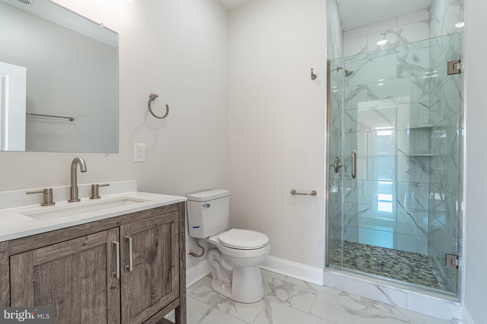 1636 South 2nd Street Philadelphia, PA 19148 - Photo 29 of 39 a bathroom with a granite countertop sink a toilet and a mirror