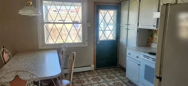 a view of kitchen with windows and refrigerator