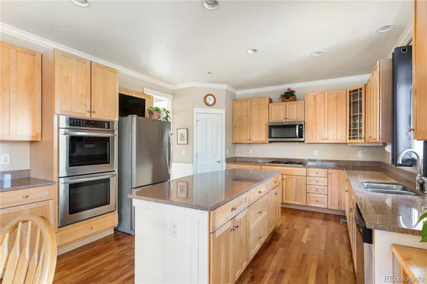 a large kitchen with stainless steel appliances granite countertop a stove a sink and a refrigerator