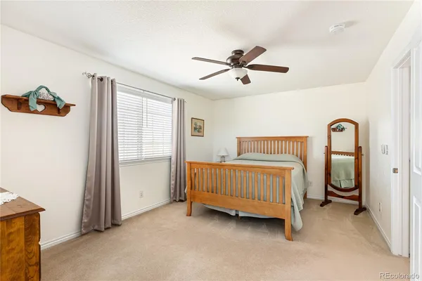 a bedroom with a bed and a ceiling fan