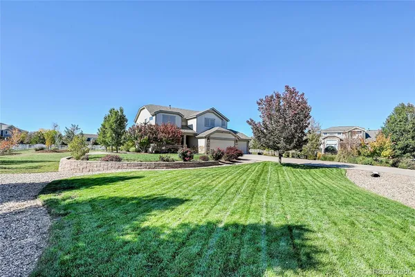 a front view of a house with yard and green space