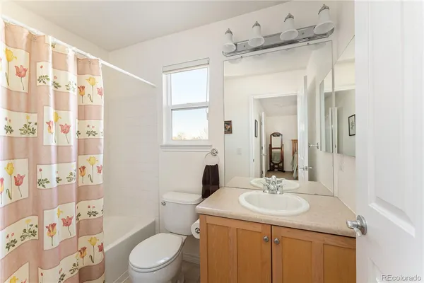 a bathroom with a sink toilet a mirror and shower curtain