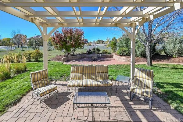 a view of a patio with a table chairs and a yard