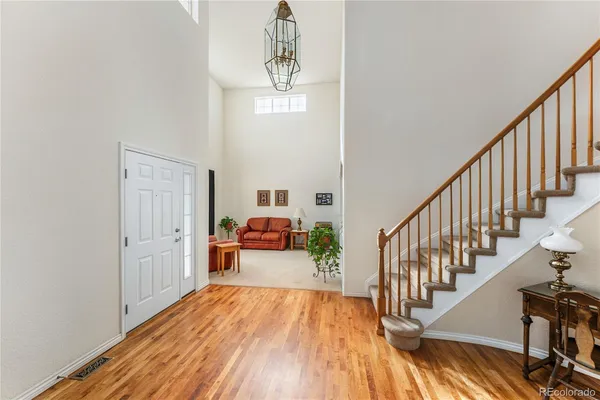 a view of a hallway with wooden floor and staircase