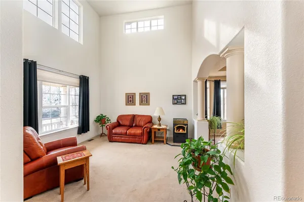 a living room with furniture a fireplace and a potted plant