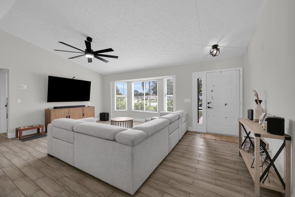 1950 Southwest Logwood Road Port St. Lucie, FL 34953 - Photo 4 of 32 a living room with furniture and a flat screen tv