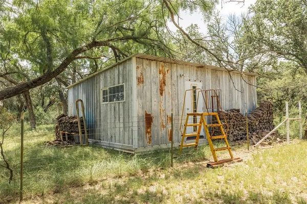 a view of a yard with wooden fence