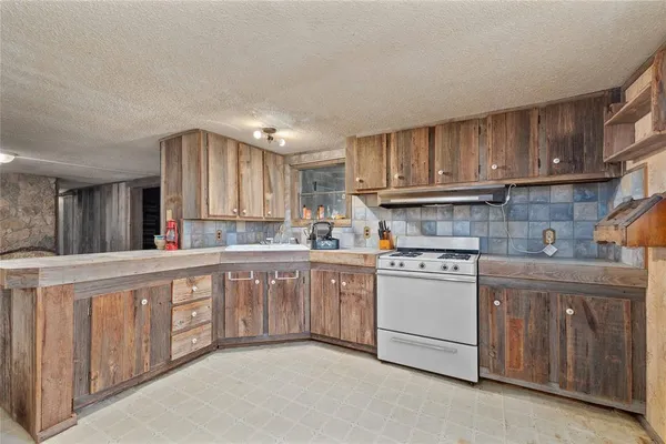 a kitchen with cabinets appliances a sink and a window
