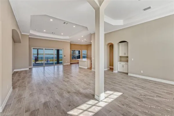 a view of a hallway with wooden floor and a living room