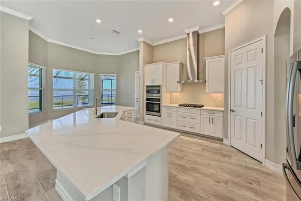 a kitchen with stainless steel appliances kitchen island granite countertop a refrigerator and cabinets