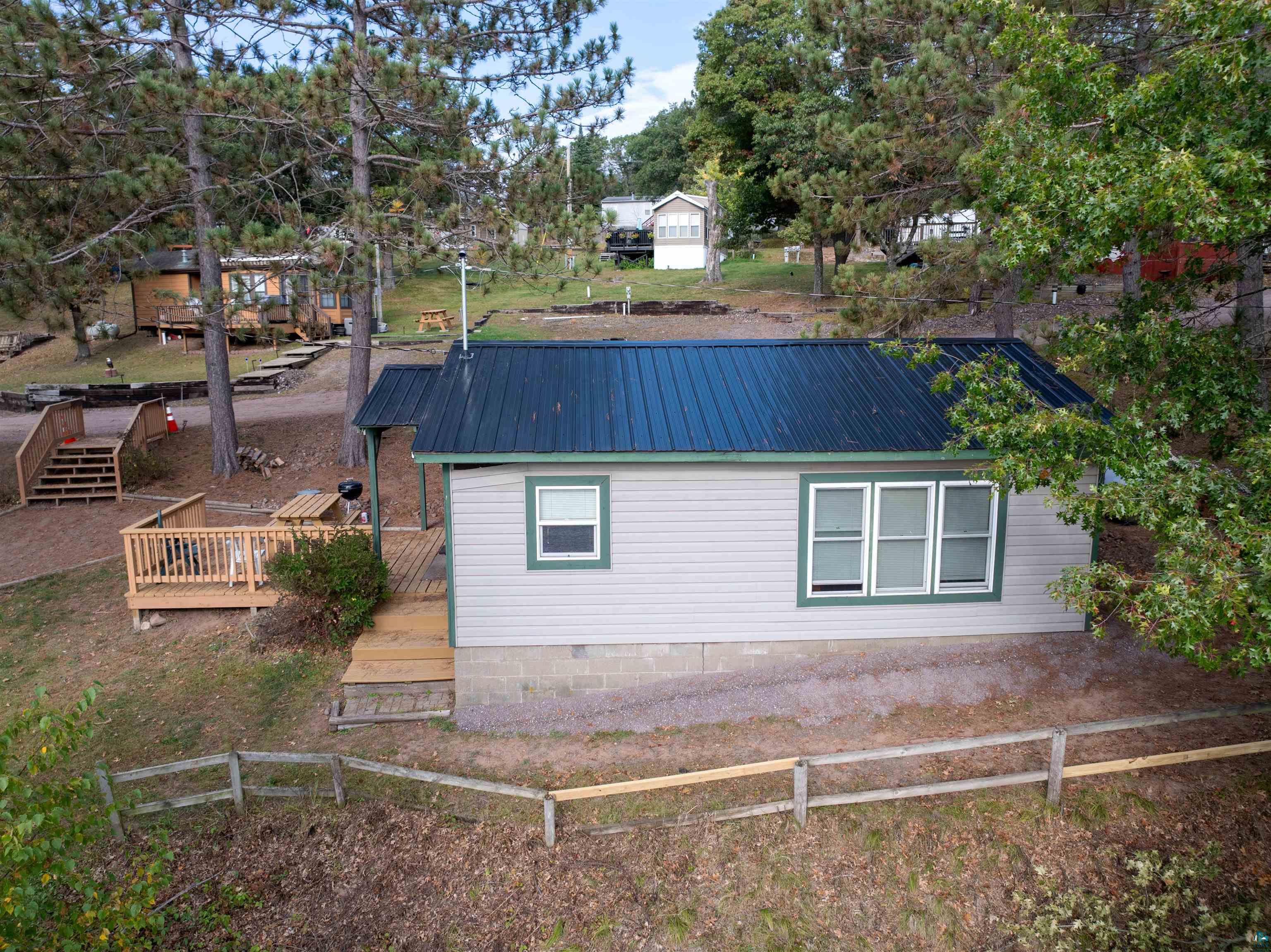 View of home's exterior featuring a deck, a metal roof, and crawl space