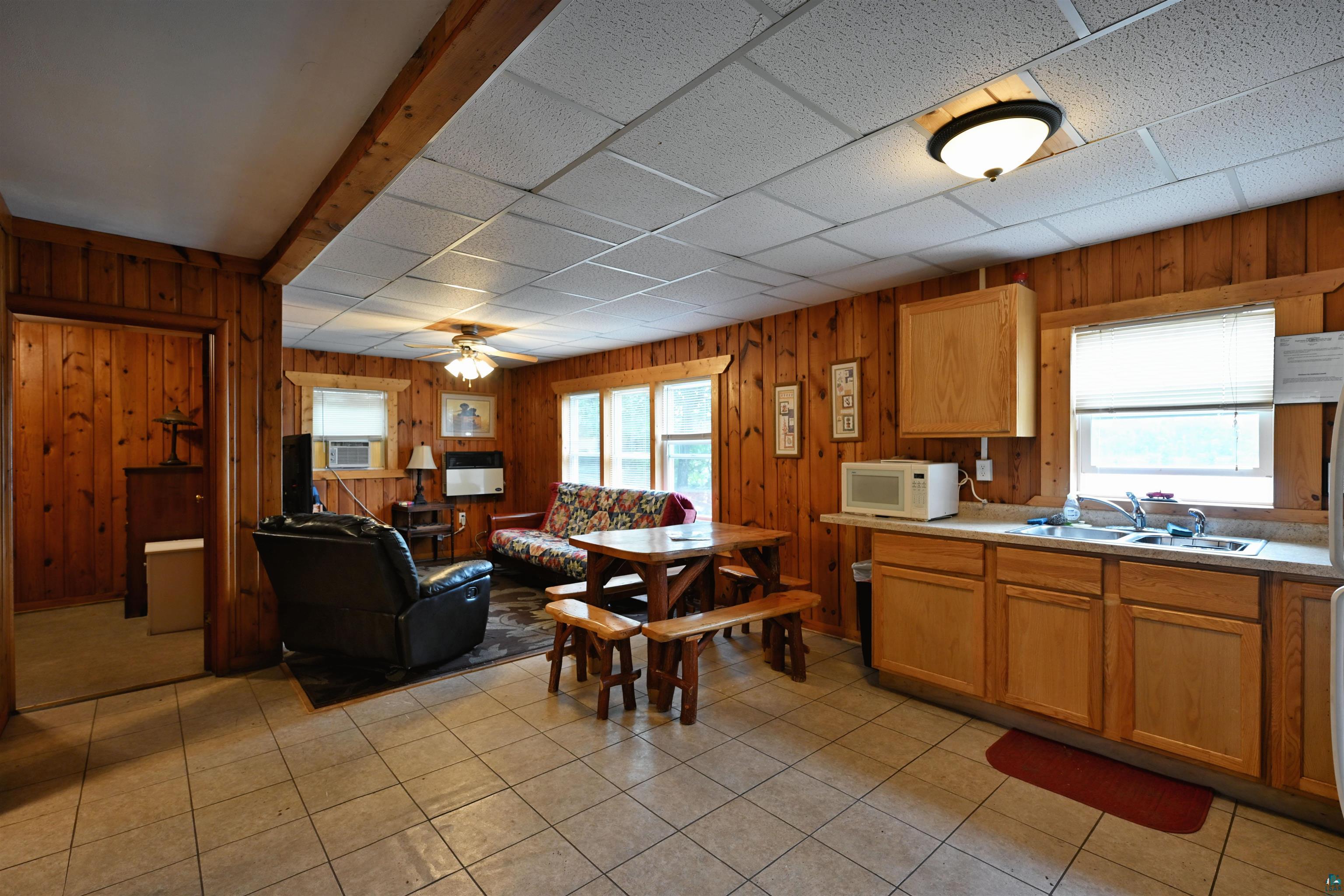 6833 View Point Lodge Road, Unit 14 Gordon, WI 54838 - Photo 33 of 34 Kitchen with light countertops, white microwave, wood walls, a paneled ceiling, and open floor plan