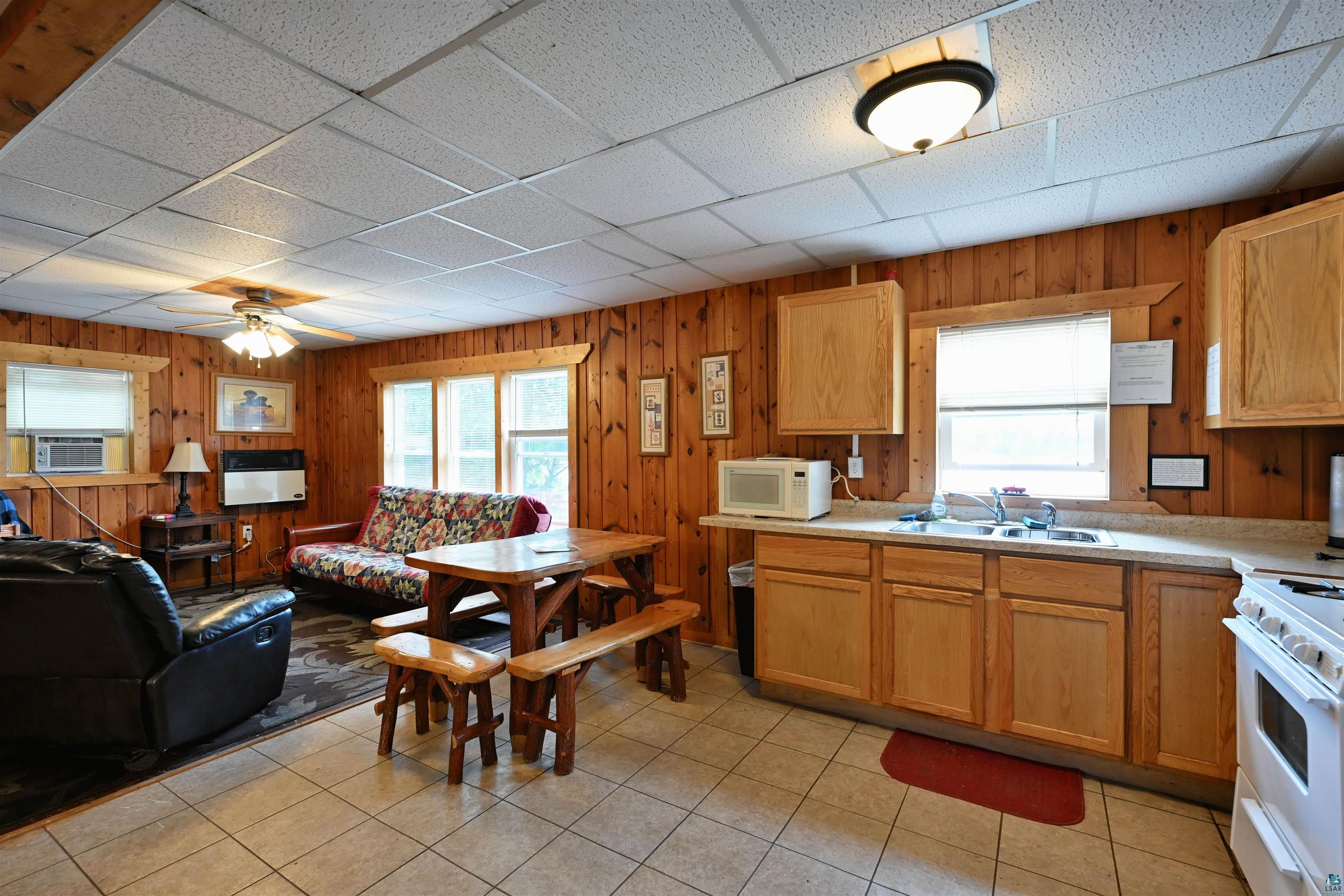 6833 View Point Lodge Road, Unit 14 Gordon, WI 54838 - Photo 34 of 34 Kitchen featuring light countertops, white appliances, open floor plan, wooden walls, and a paneled ceiling