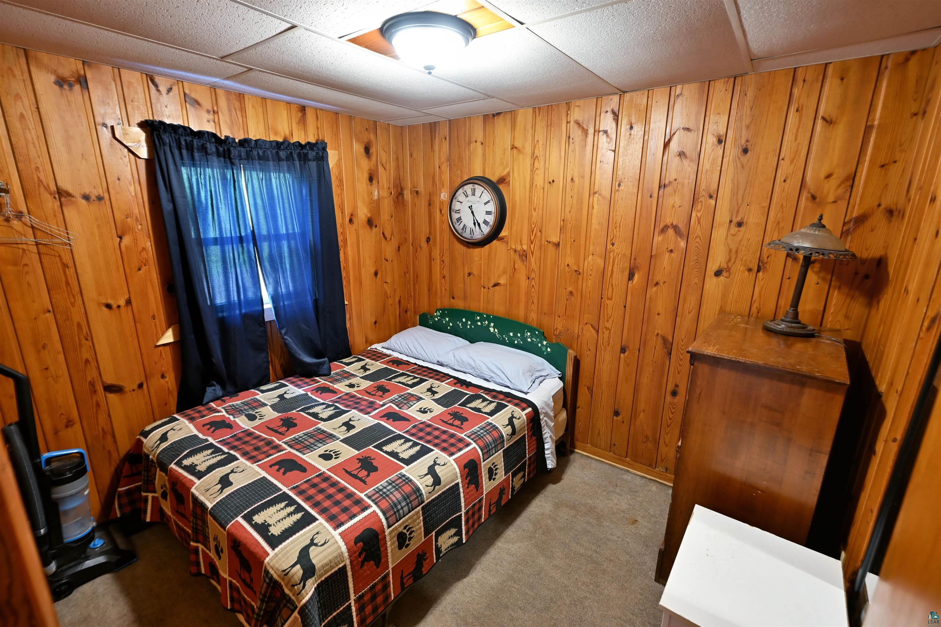 6833 View Point Lodge Road, Unit 14 Gordon, WI 54838 - Photo 19 of 34 Bedroom featuring carpet floors, wood walls, and a drop ceiling