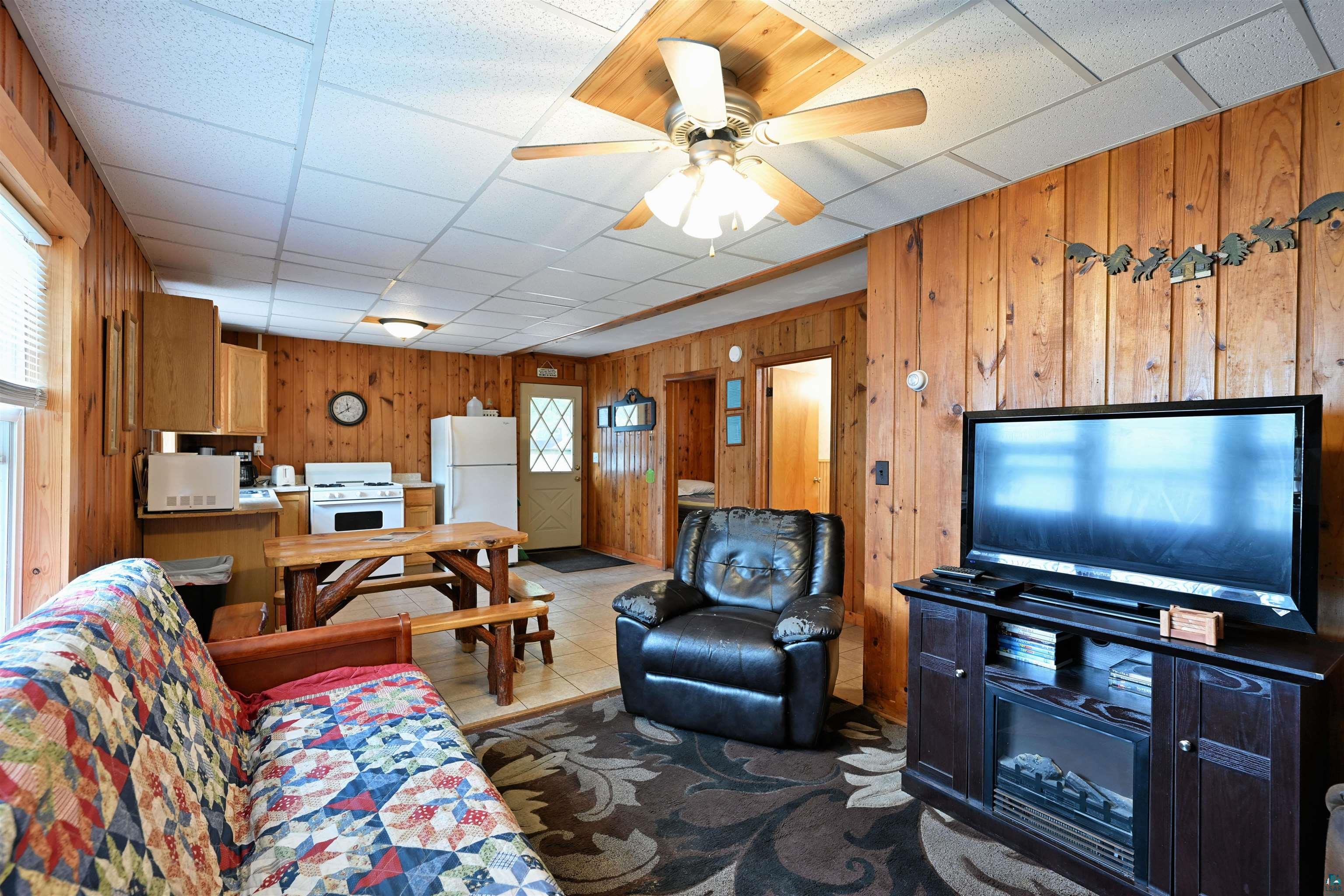 6833 View Point Lodge Road, Unit 14 Gordon, WI 54838 - Photo 21 of 34 Living room with wooden walls, a paneled ceiling, and a ceiling fan