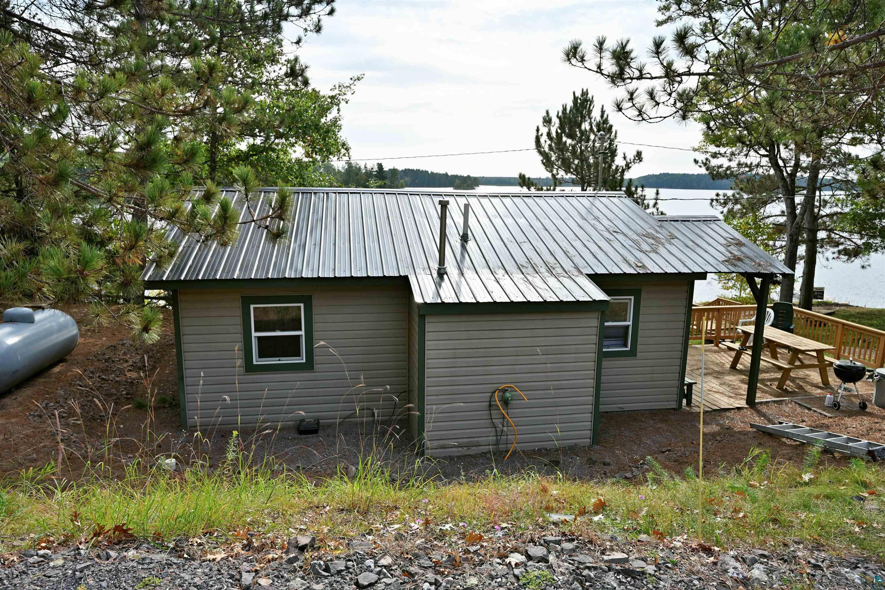 6833 View Point Lodge Road, Unit 14 Gordon, WI 54838 - Photo 30 of 34 View of home's exterior with a patio area and a metal roof