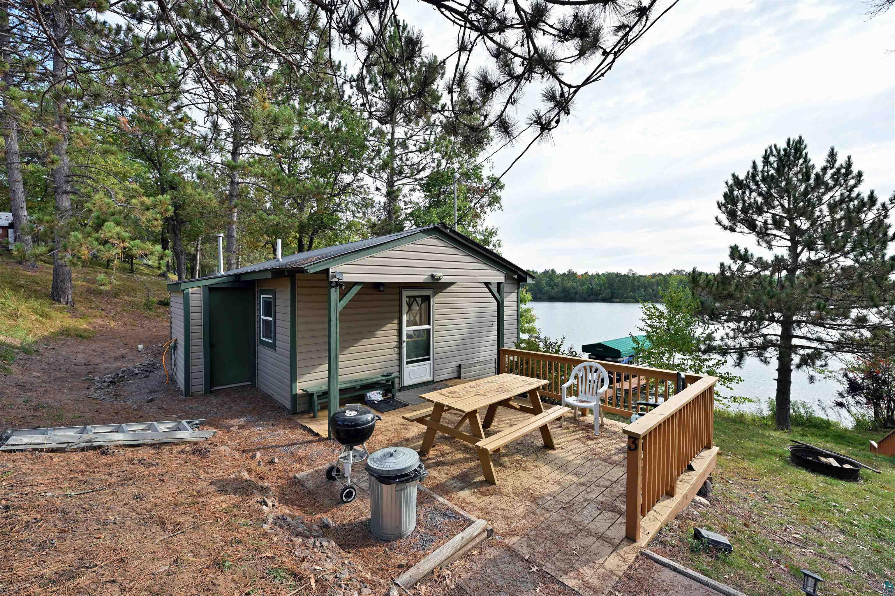 6833 View Point Lodge Road, Unit 14 Gordon, WI 54838 - Photo 31 of 34 Wooden deck featuring a fire pit, an outbuilding, a water view, and grilling area