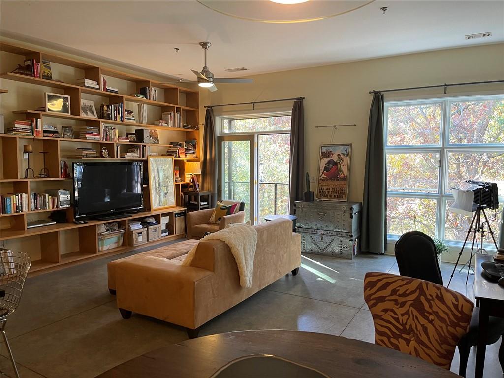 560 Dutch Valley Road Northeast, Unit 2406 Atlanta, GA 30324 - Photo 1 of 1 a living room with furniture and a flat screen tv
