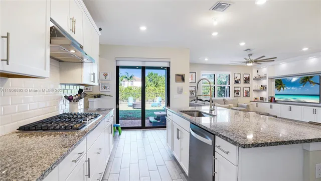 a kitchen with stainless steel appliances granite countertop a sink stove and cabinets