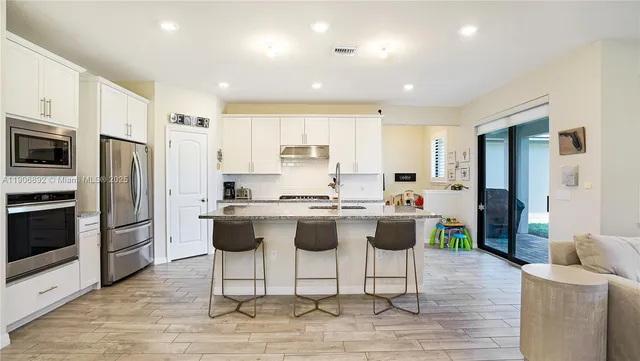 a bedroom with a large bed a painting on the wall and a lamp