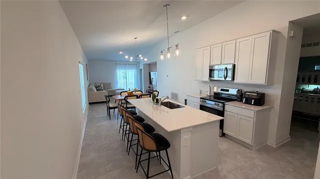 a kitchen with kitchen island a stove a table and chairs