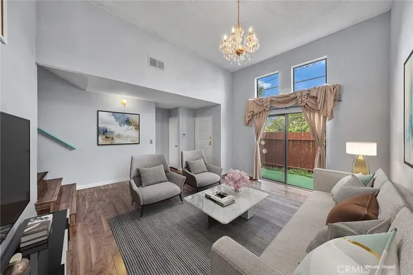 a living room with furniture and a wooden floor