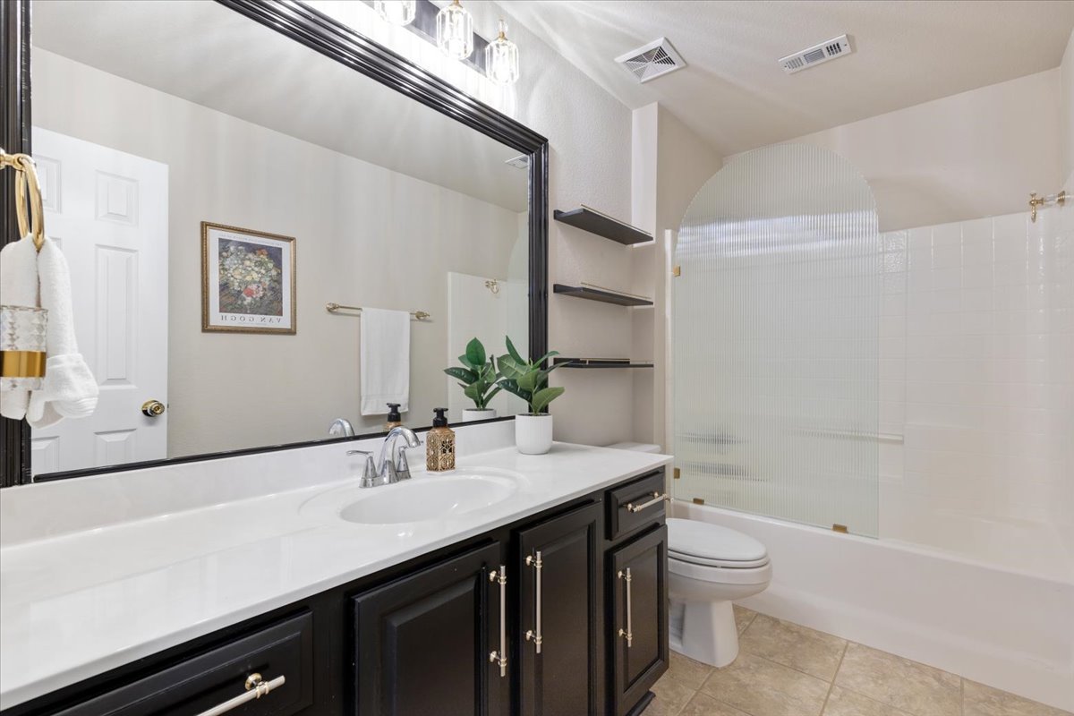 2501 Aspen Meadow Road Leander, TX 78641 - Photo 24 of 30 Bathroom vanity featuring a single basin, white countertop, and dark cabinetry with silver-toned hardware